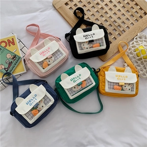 Detail of colorful canvas crossbody bags with rabbit ears and cute plush accessories