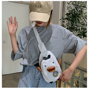 Detail of cute white duck canvas chest bag featuring a plush orange beak and graphic badge