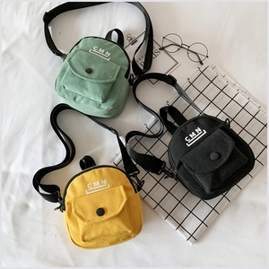 Détail de mini sacs bandoulière en toile verte, noire et jaune avec sangles réglables