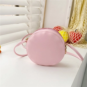Close-up of pink round donut-shaped girl crossbody bag with zipper and PU leather texture