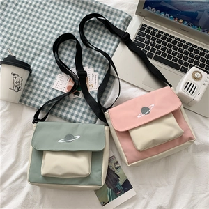Detail of canvas crossbody bags with planet embroidery and adjustable shoulder straps