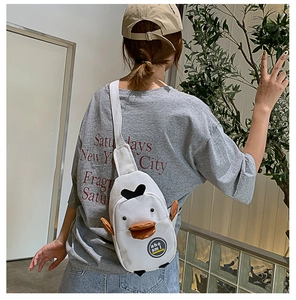 Detail of cute white canvas duck bag with 3D beak and wings worn as a crossbody pack