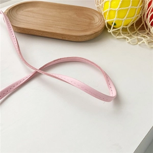 Close-up of pink leather shoulder strap featuring precise stitching for girl's donut bag