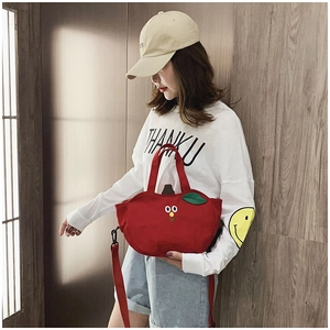 Détail du sac pomme rouge en toile avec broderie mignonne et bandoulière réglable