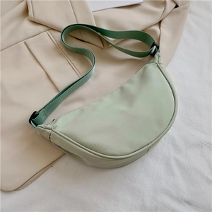 Detail of light green nylon crescent crossbody bag with adjustable wide fabric strap