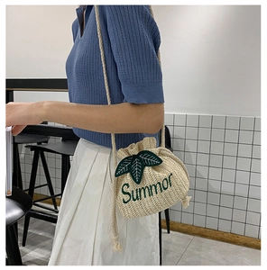 Detail of straw bucket bag with Summor embroidery and 3D green leaf accents