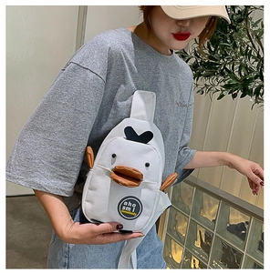 Detail of cute duck-shaped canvas chest bag with 3D beak and embroidery on model