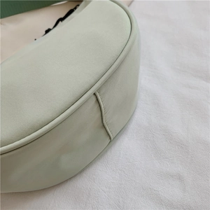 Detailed view of durable nylon fabric and reinforced stitching on the crescent bag base