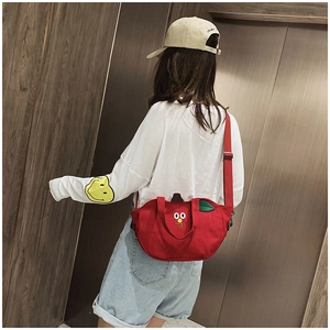 Vue arrière d'un sac bandoulière rouge en toile forme pomme avec broderie sur mannequin