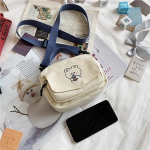 Detail of canvas crossbody bag with cute bear embroidery and navy blue strap