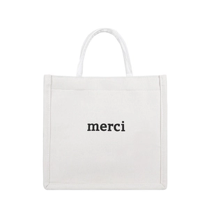 Minimalist white canvas tote bag with black merci print and sturdy fabric handles