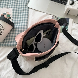 Pink canvas crossbody bag interior view showing large storage capacity for accessories