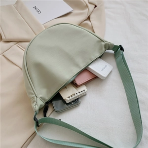 Detail showing high-capacity nylon crescent bag with smartphone and daily essentials