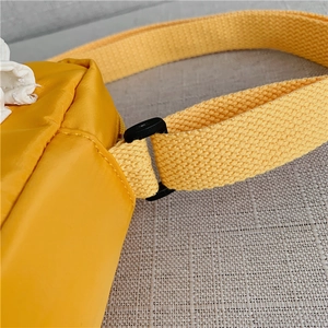Close-up of durable yellow nylon strap connection with black adjustable buckle and stitching