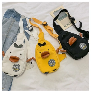 Detailed flat lay of cartoon duck canvas chest bags in white, yellow, and black colors