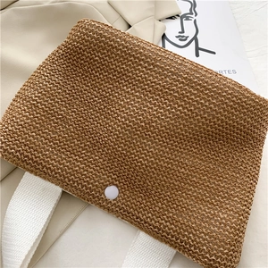 Detail der handgewebten Strohtasche mit Rautenmuster und weißem Segeltuchriemen für Strand