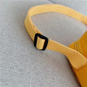 Close-up of yellow nylon shoulder strap with adjustable black plastic buckle and zipper