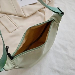 Detail view of mint green nylon dumpling bag showing interior lining and black zipper
