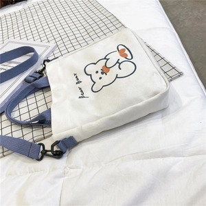Detail of cute bear illustration and orange Bear Bear text on white canvas bag