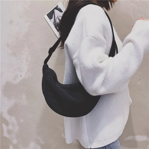 Side view of a black nylon hobo bag worn by a model, showcasing the minimalist casual style