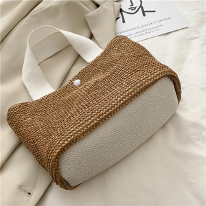 Detail der gewebten Strohtasche mit weißem Kunstlederfuß und passenden Griffen