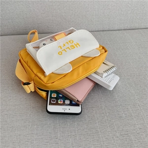 Interior storage capacity of a yellow canvas crossbody bag with cute bear ear flap