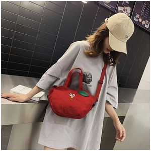 Détail du sac bandoulière en toile rouge avec broderie mignonne et bandoulière réglable