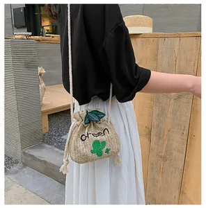 Close-up of straw bucket bag featuring green cactus embroidery and cotton rope strap