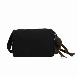 Borsa a tracolla in tela nera capiente con un portachiavi a forma di scimmia di peluche