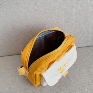 Top view of yellow canvas crossbody bag showing inner lining and metal zipper details