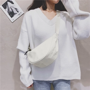 White nylon crescent crossbody bag styled with a white knit sweater and jeans