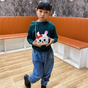 Cute white bunny crossbody bag with red bow shown on a young girl in an indoor setting