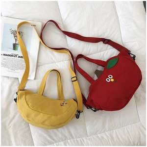Détail des sacs en toile rouge et jaune avec yeux de dessin animé et bandoulières réglables