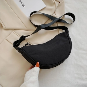 Detail of minimalist black nylon crescent bag with adjustable wide shoulder strap