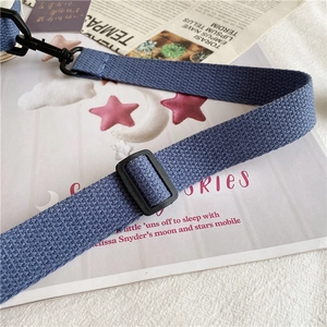 Detail of blue thickened twill canvas strap with matte black metal swivel hooks and buckles
