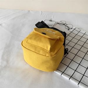 Sac bandoulière en toile jaune avec poche à lettres CMN vu sous un angle de dessus