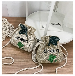 Detail of mini straw bucket bags with cactus embroidery and green leaf drawstring