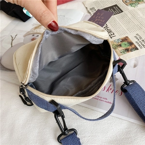 Internal view of cream canvas crossbody bag showing gray fabric lining and zipper closure