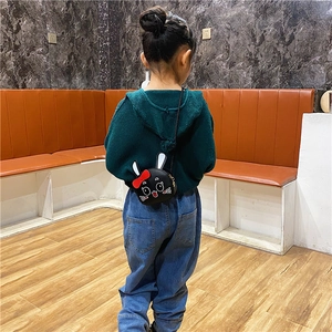 Rear view of child wearing a mini black cartoon rabbit crossbody bag with red bow detail