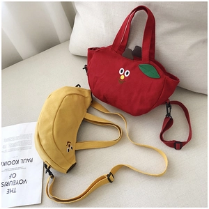Détail de sacs à bandoulière mignons en toile pomme et banane avec broderie et sangles