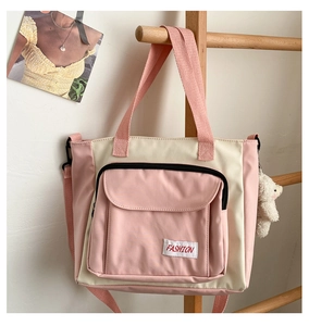 Detail of pink and beige canvas bag featuring front zipper pocket and cute plush bear charm
