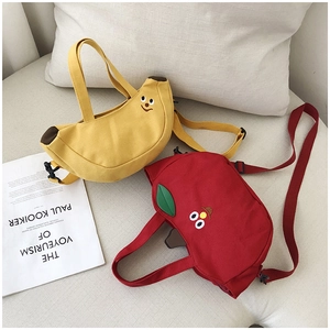 Détail de sacs en toile en forme de banane et de pomme avec broderies et bandoulières