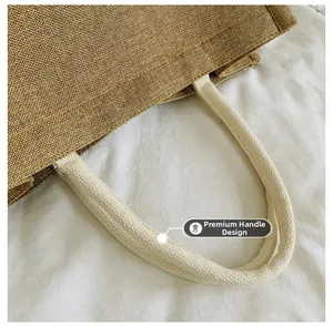Detail of reinforced white cotton rope handle on natural jute tote bag for heavy duty
