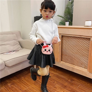 Little girl wearing a pink rabbit-shaped crossbody bag with a cute red bow detail