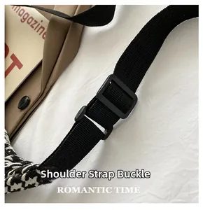 Detail of adjustable black nylon strap with plastic buckle on houndstooth crossbody bag