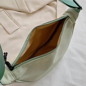 Light green nylon dumpling cross-body bag with wide shoulder strap and spacious interior