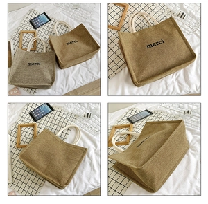 Detail view of large linen tote bags with merci print and sturdy rope handles