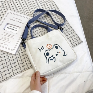 Detailed view of cream canvas tote with blue bear print and adjustable straps