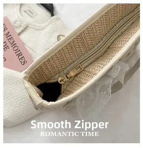 Detail of smooth gold zipper closure and lace trim on a woven straw tote bag