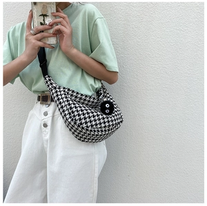 Detail of checkered canvas crossbody bag with adjustable strap and cute plush charm
